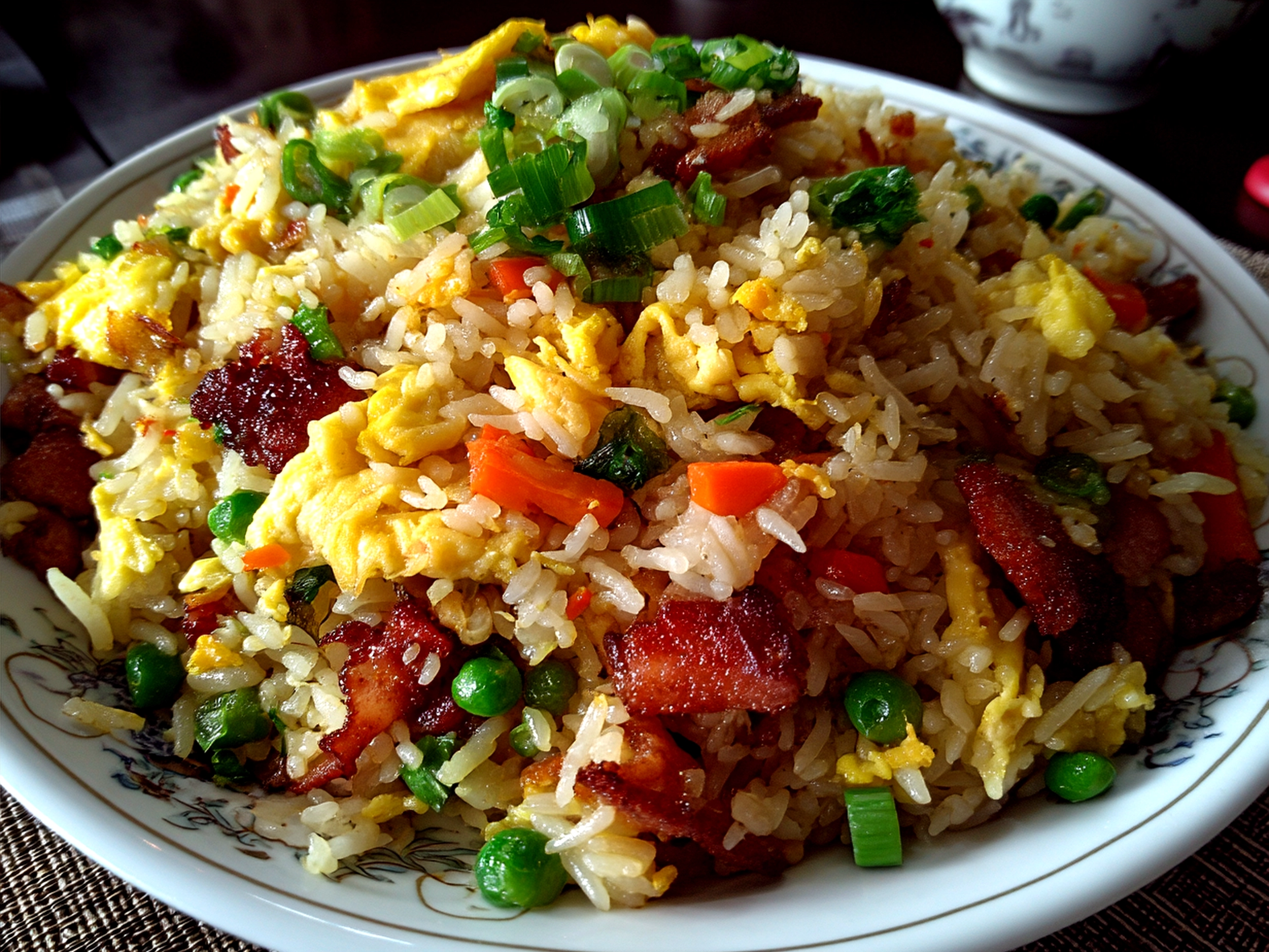 A bowl of freshly served Bang Bang Fried Rice garnished with sesame seeds and green onions